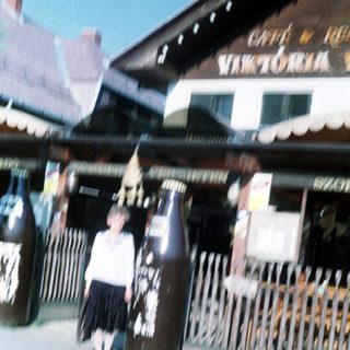 Child standing beside large beer kegs at Café Victoria.