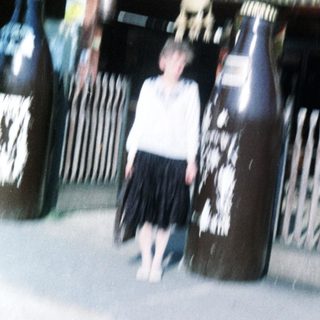 Child standing beside large beer kegs at Café Victoria.