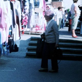 Outdoor clothing market stall with various garments.