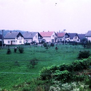 Residential neighborhood with green fields and houses.