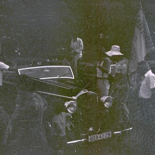 Group of people in vintage car during nighttime event.