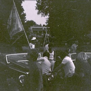 Vintage parade with people waving flag.