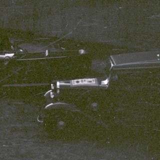 Vintage funeral procession with hearse and mourners.