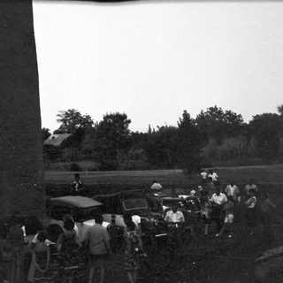 Group of people gathered outdoors near a monument.