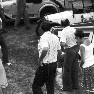 Vintage gathering near classic cars.