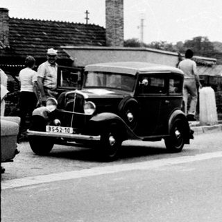 Vintage street scene with long line of vintage cars.
