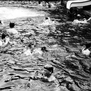 People swimming and playing in a lake.