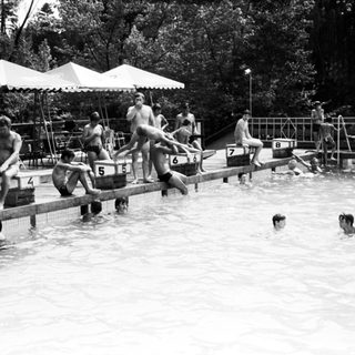 Water polo match in progress at an outdoor pool.