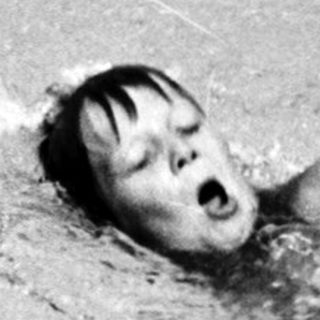 Person swimming underwater in pool.