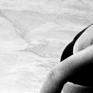 Person swimming in turbulent water near shore.