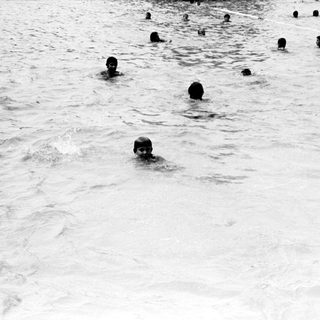 Group of people swimming in cold water.