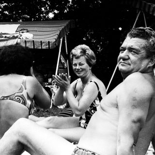 People enjoying outdoor gathering by poolside.
