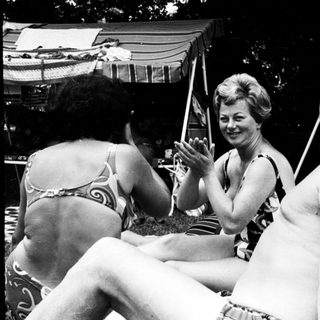 People enjoying outdoor gathering by poolside.