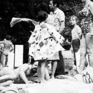 People relaxing and sunbathing outdoors in park.