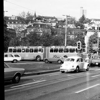 Busy urban street intersection with vintage cars.