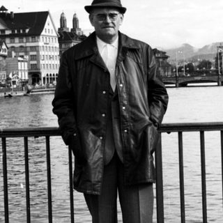 Man in vintage attire posing by waterfront.