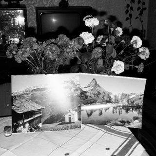 Vintage interior with flowers, old TV, mountain postcards.