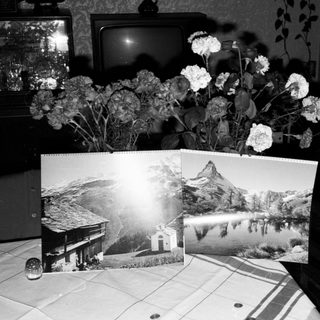 Vintage interior with flowers, old TV, mountain postcards.