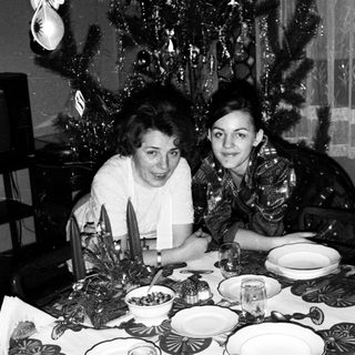 Two women seated at festively set Christmas table.