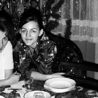 Two women seated at festively set Christmas table.