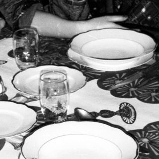 Two women seated at festively set Christmas table.