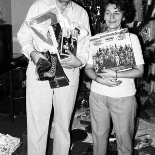 Two people holding awards and magazines indoors.