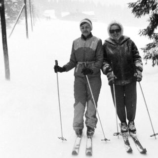 Two people skiing on snow-covered trail.