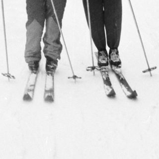 Two people skiing on snow-covered trail.