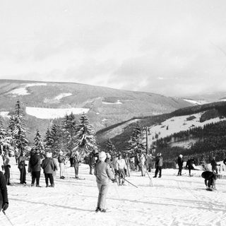 People skiing on snowy mountain slope.