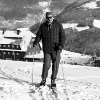 Man cross-country skiing in snowy mountainous landscape.