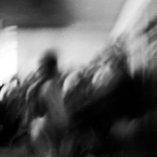 Blurred crowd in motion, indistinct figures.