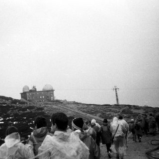Group of people hiking toward mountain observatory.