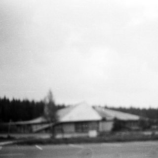 Blurry black-and-white photo of a rural building complex.