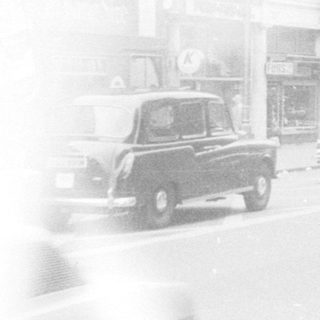 Busy mid-20th-century European city street scene.