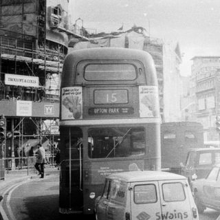 Classic London street scene with vintage double-decker buses.