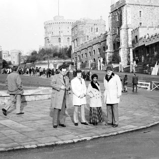 Historic castle grounds with people walking and posing.