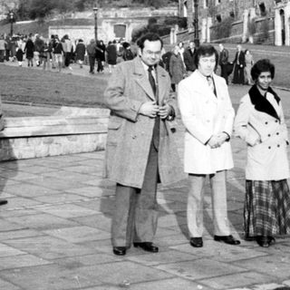 Historic castle grounds with people walking and posing.