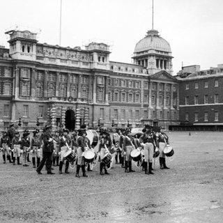 Military band marching in front of Buckingham Palace.