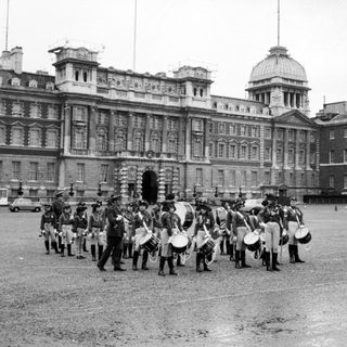 Military band marching in front of Buckingham Palace.