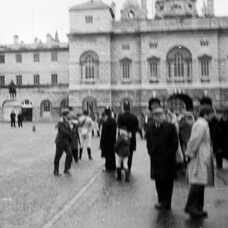 Historic building courtyard with people walking and children playing.