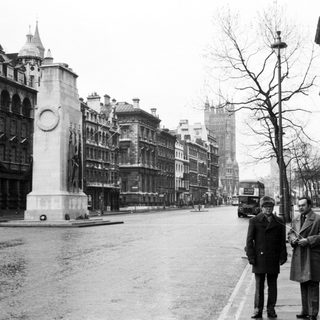 Two men standing near Nelson's Column in London.