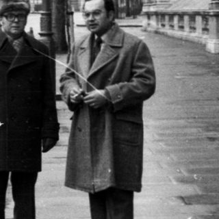 Two men standing near Nelson's Column in London.