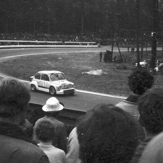 Classic race car driving on curved track.