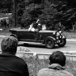 Classic vintage car race with spectators watching.