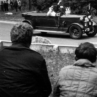 Classic vintage car race with spectators watching.
