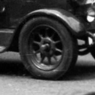 Classic vintage car race with spectators watching.