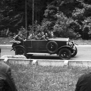 Vintage car race with spectators watching.