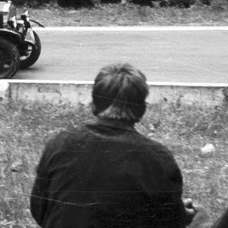 Vintage car race with spectators watching.