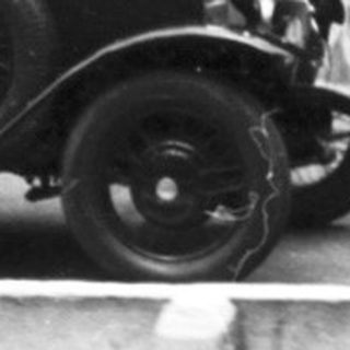 Vintage car race with spectators watching.
