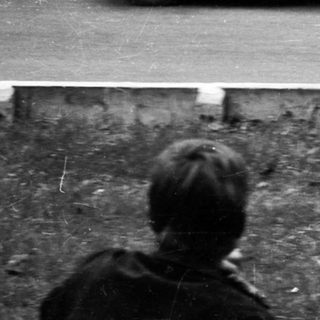 Classic race car driving on winding road.